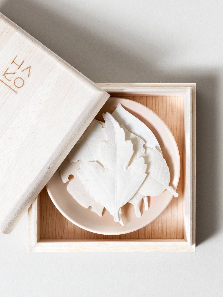 Wooden box containing HA KO Paper Incense leaves on a dish, showcasing an elegant gift set for relaxation.