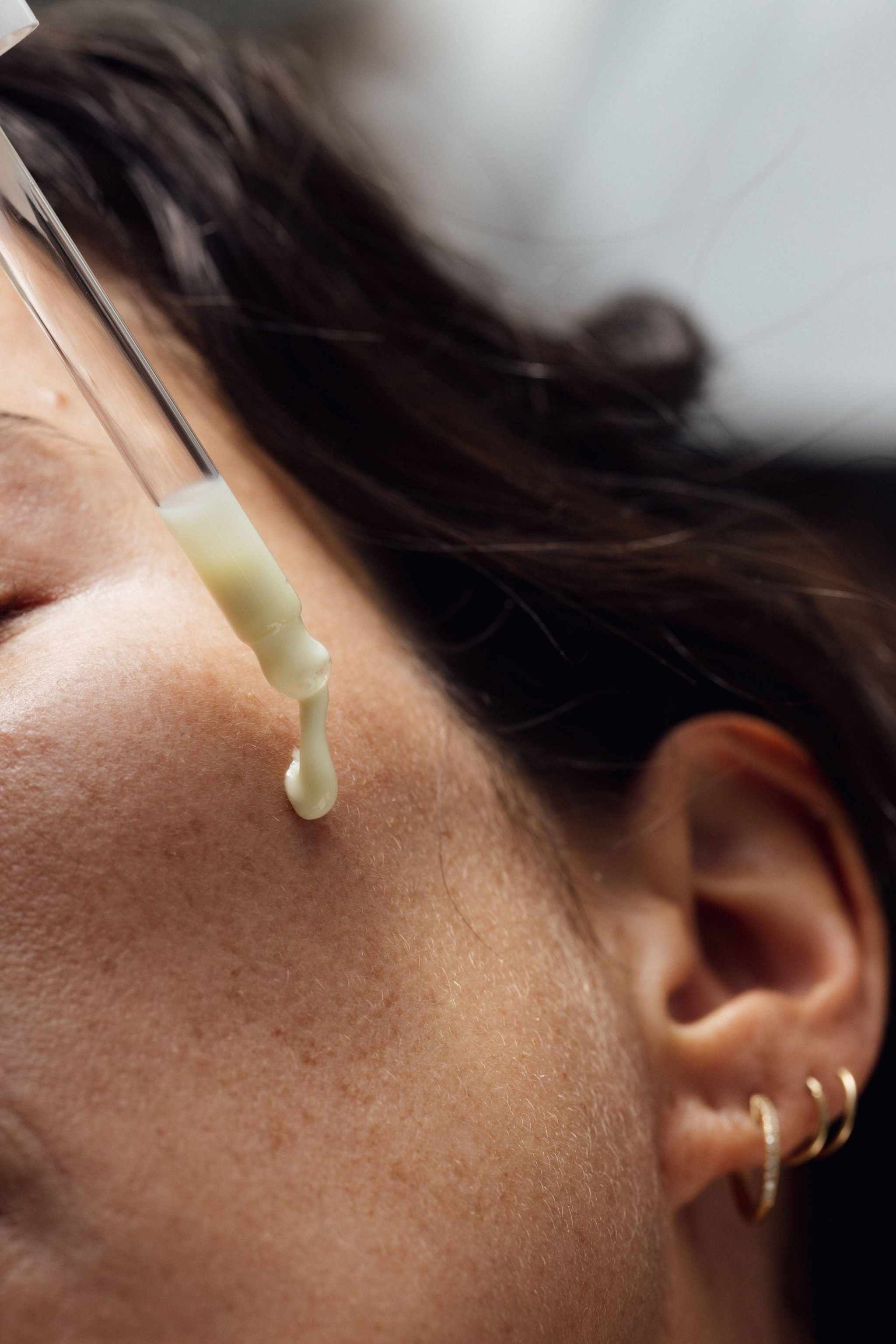 Close-up of applying the Enlightening Night Serum for deep hydration and radiant skin.