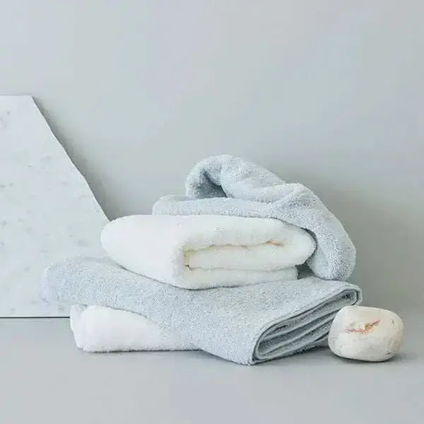 HIKOTA Imabari Japan Towels in premium fabrics on marble surface.