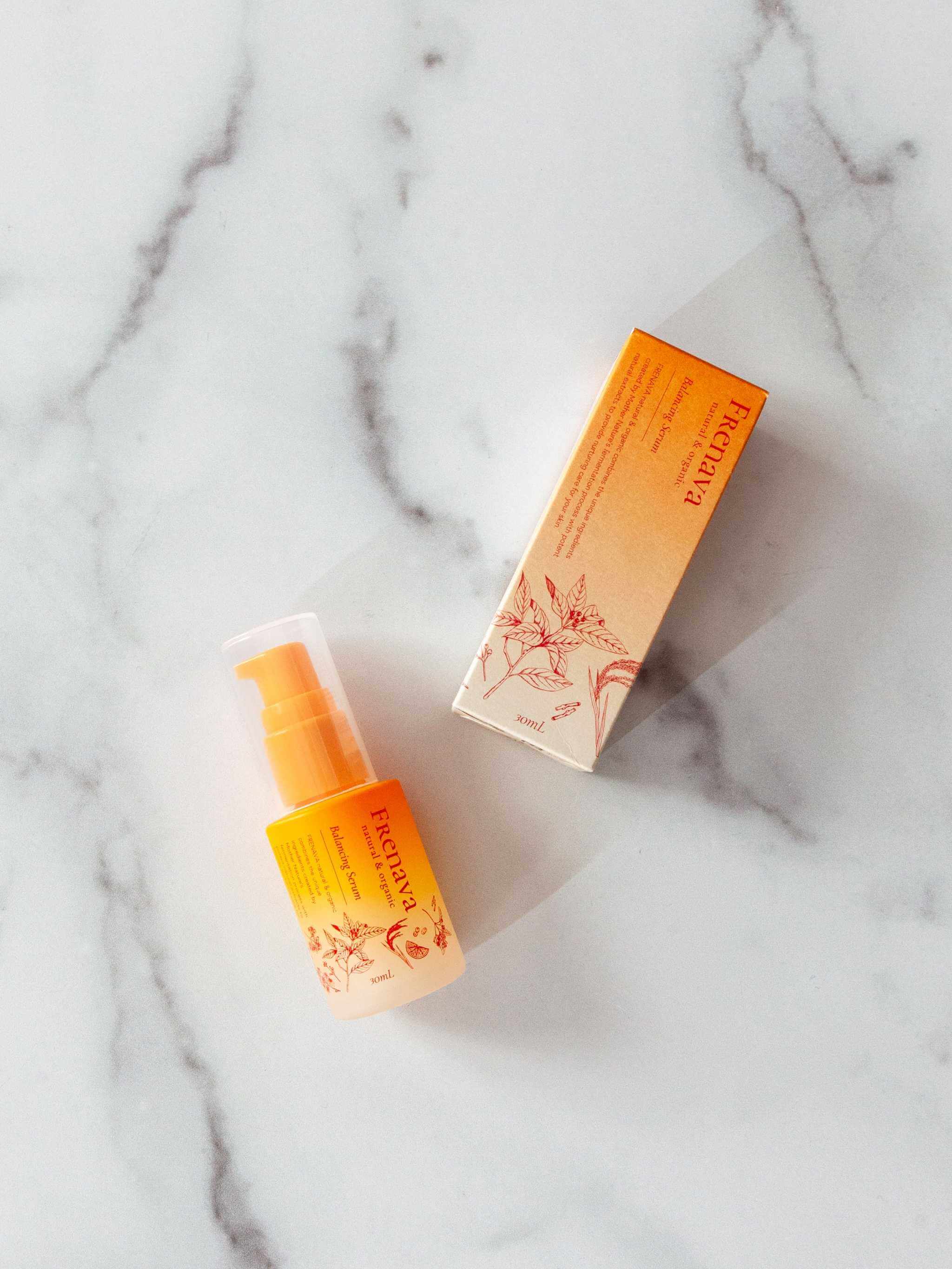 Frenava Balancing Serum bottle and box with organic extracts on marble surface.