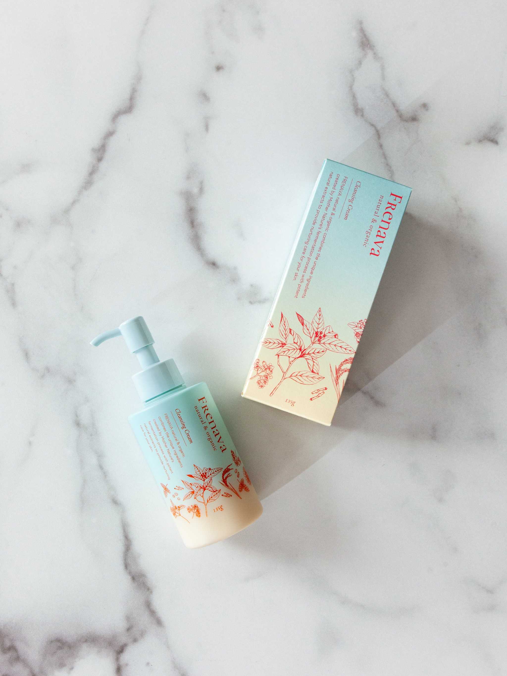Frenava Cleansing Cream with emulsion-like texture and hydrating ingredients, in bottle and box on marble surface.
