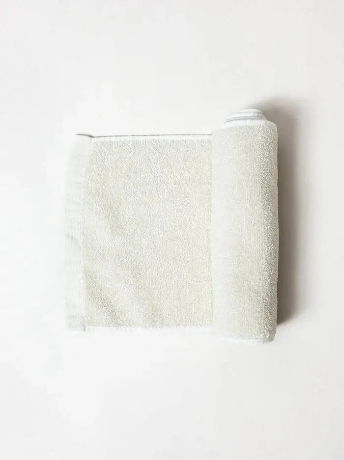 Folded beige towel on a white
