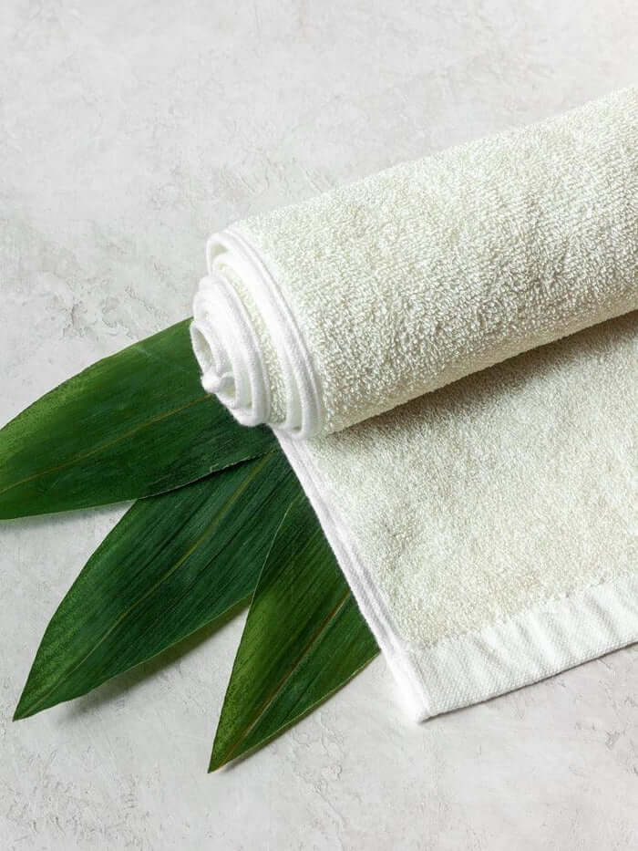 Rolled-up white towel with green leaves