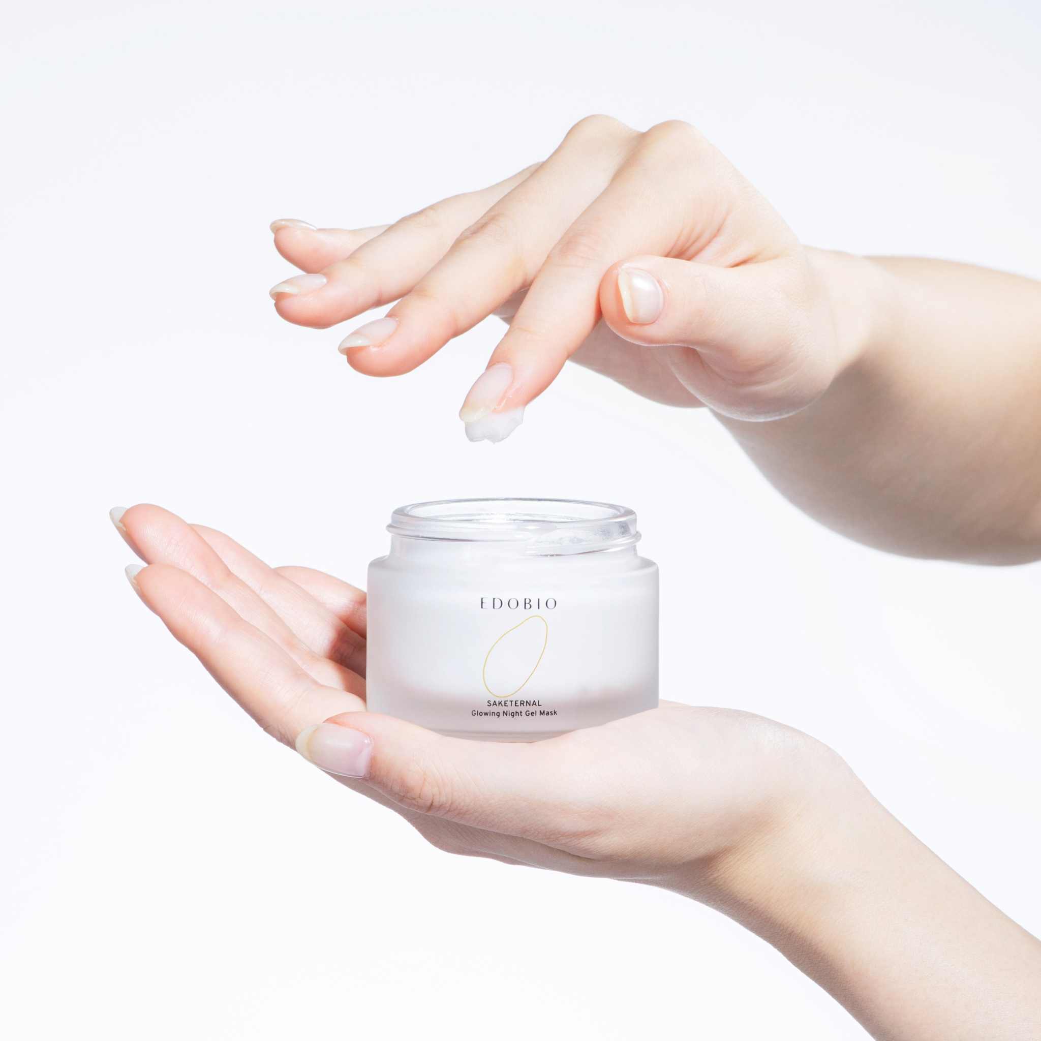 Glowing Overnight Gel Mask in a jar, demonstrated on hands for skin rejuvenation.
