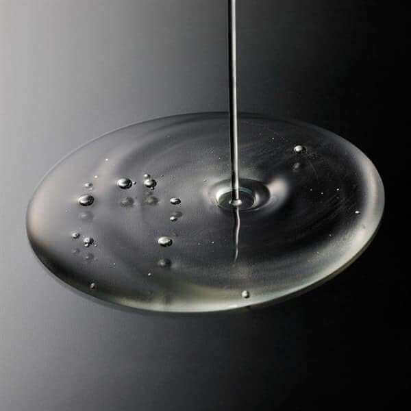 Clear liquid texture of Ruhaku Gettou Balancing Lotion on a dark surface, highlighting its hydrating and protective properties.