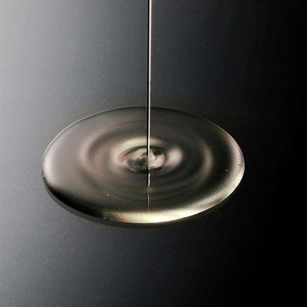 Gettou Night Repair Overnight Face Oil being poured onto a dark surface.