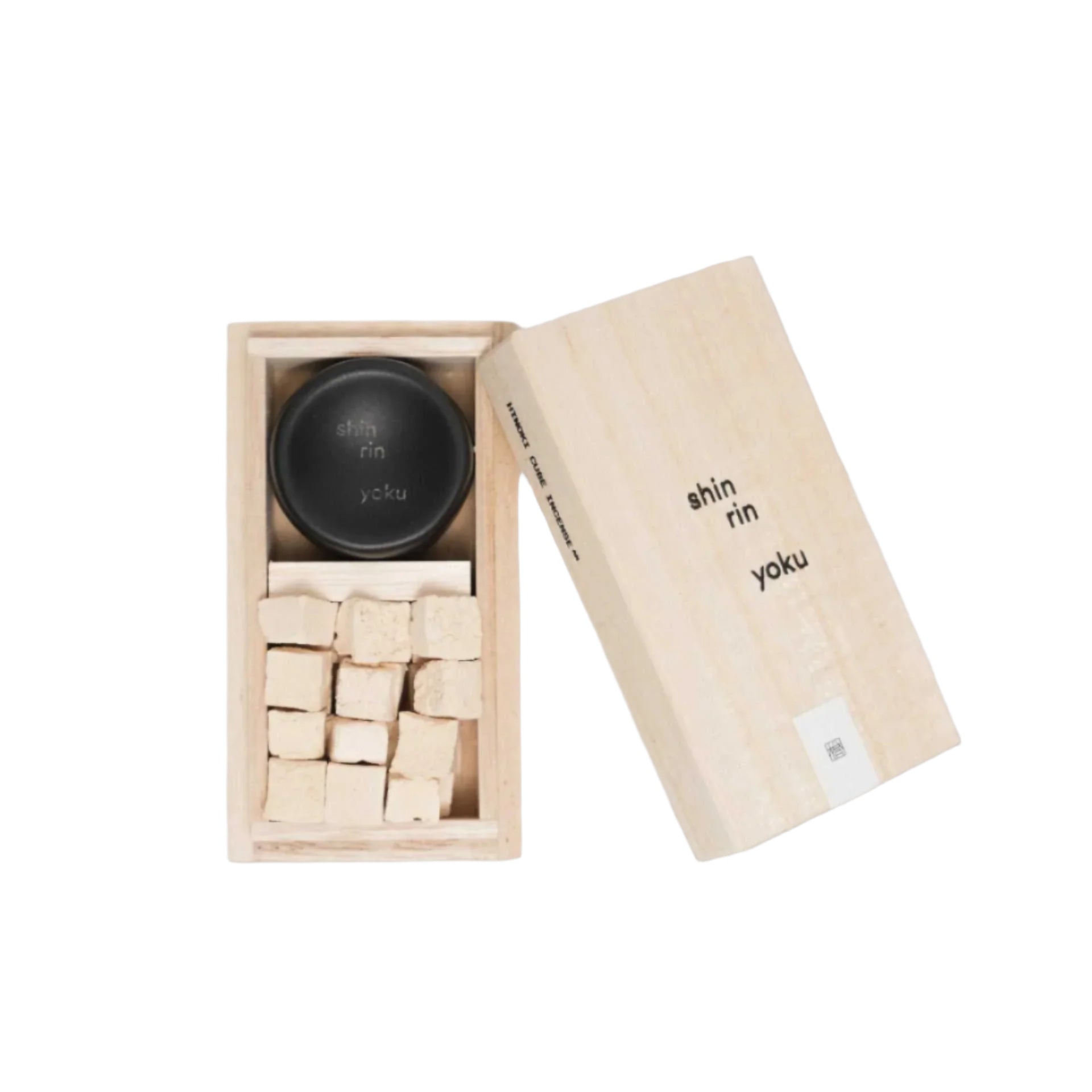 Hinoki incense cubes in a wooden box with black lid, made from Hinoki essential oil for tranquility.