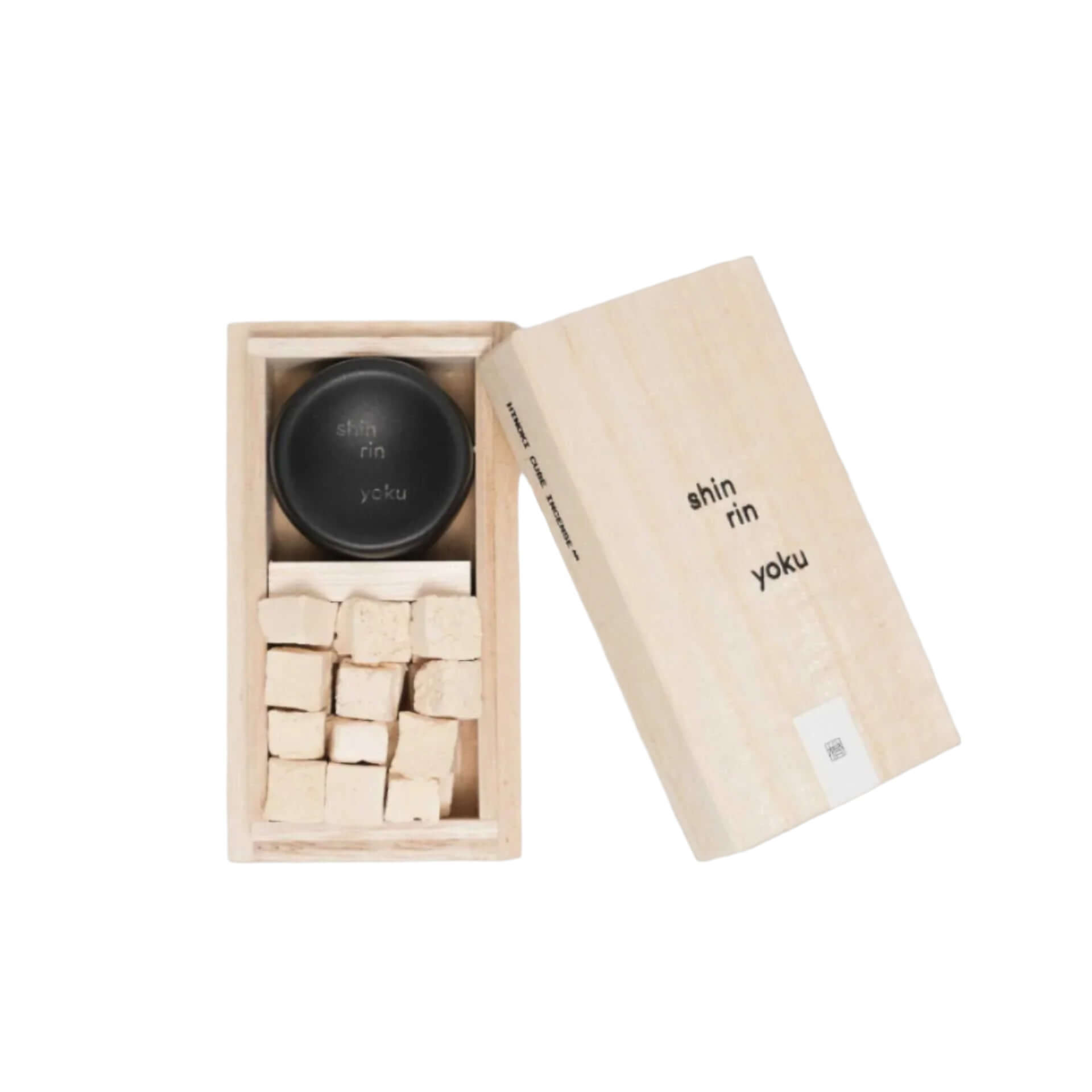 Hinoki incense cubes in a wooden box with black lid, made from Hinoki essential oil for tranquility.