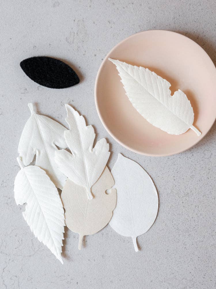 HA KO Paper Incense leaves displayed on a dish with a felt mat, perfect for soothing aromatherapy.