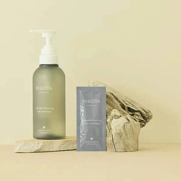 HIKOTA Complete Cleansing Hair Treatment bottle and sachet on a natural wood display.