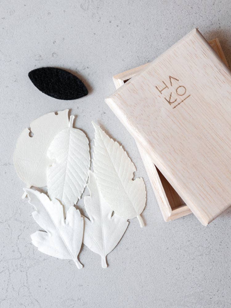 HA KO Paper Incense wooden box set with five white incense leaves and black felt mat on gray background.